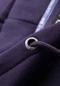 Tissu de sweat-shirt marine avec un œillet en métal et un cordon de serrage tressé mettant en avant un design fonctionnel ; surface texturée avec une finition lisse.