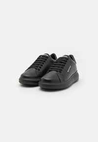 Black leather sneakers with a rounded toe, flat rubber sole, and lace-up closure; features a logo on the side and textured detailing.