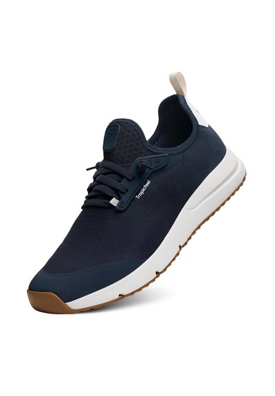 Námořnické modré síťované tenisky s bílou a tan gumovou podrážkou, disponující kulatými tkaničkami, akcenty s logem a poutkem na patě pro snadné obouvání.