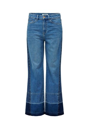 Vaqueros de mezclilla azul claro con diseño de pierna ancha, con paneles en azul más oscuro en el dobladillo y las costuras laterales. Cuentan con cierre de botón.