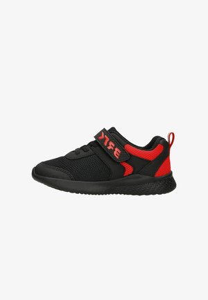 Black mesh sneaker with red accents, Velcro strap, cushioned sole, and textured rubber outsole for grip. Lightweight and breathable design.