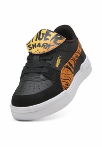 Baskets Puma noires et oranges avec semelle blanche, motif rayures de tigre, et languette jaune avec le texte audacieux "TIGER SHARK".