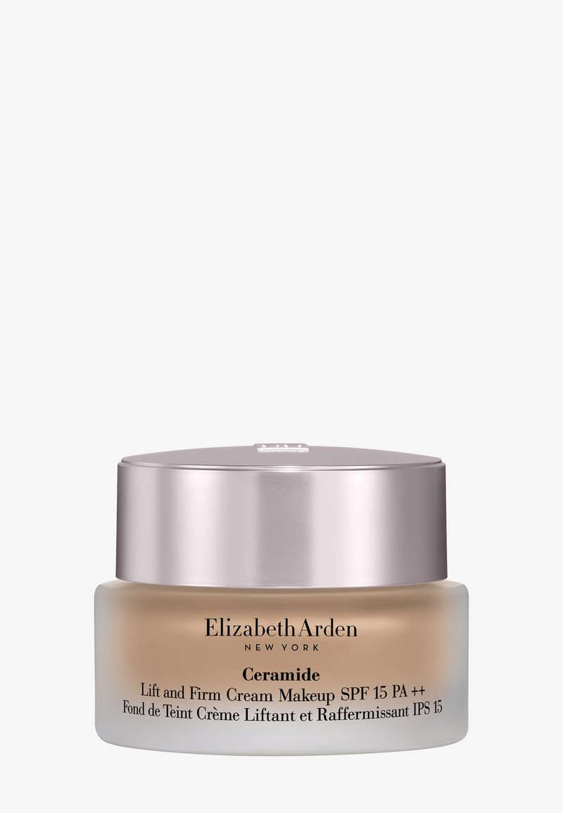 Ceramide Lift and Firm Creme-Make-up in einem klaren Glasbehälter mit metallic-silbernem Deckel. Enthält LSF 15 und ist beige gefärbt.