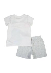 T-shirt blanc à manches courtes avec col rond, associé à un short gris clair. Tissu en mélange de coton avec une texture douce et une ceinture élastique.