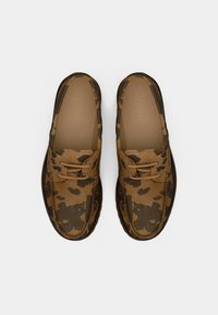 Mocassins em padrão de camouflage castanho e castanho escuro com detalhes em rendinha, vistos de cima sobre um fundo branco.