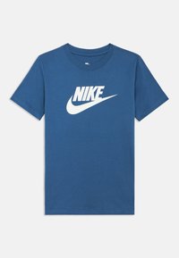 Niebieska bawełniana koszulka z dużym białym logo Nike na przodzie. Krótkie rękawy i standardowy, okrągły dekolt.