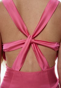 Rosa Satinkleid mit einem tiefen Rückendesign und verdrehten Trägern, die einen komplexen Knoten bilden. Glatte Textur und klare Linien im gesamten Kleid.