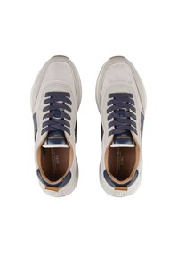 Sneaker con una toma beige chiaro, dettagli blu navy e suola in gomma. Presenta chiusura con lacci, colletto imbottito e logo sulla linguetta.