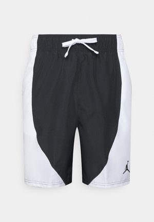 Shorts de sport noir et blanc avec une taille élastique, un cordon de serrage, des panneaux latéraux inclinés et un logo Jordan sur la partie inférieure de la jambe gauche.