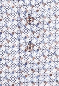 Overhemd met knopen, voorzien van een geometrisch patroon in blauw, bruin en wit, met een gladde textuur en een opvallend knoopdetail.