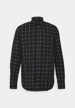 Schwarze Hemdjacke mit einem kleinen, weißen geometrischen Muster. Lange Ärmel, spitzes Kragen und gerader Schnitt. Weicher Stoff.