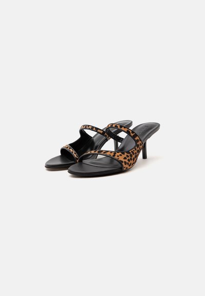 Paire de sandales à talons noires à bout ouvert avec des brides à imprimé léopard sur les orteils et le milieu du pied sur fond blanc.