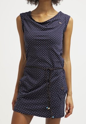 Donkerblauwe mouwloze jurk met kleine roze polkadots, een coltruihals, zijzakken met knopen en een dunne touwceintuur met kralen.