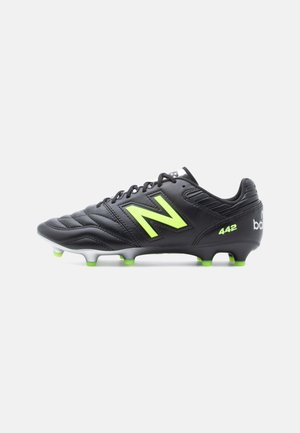 Black soccer cleat with a textured upper, featuring green accents and a prominent "N" logo. It has a molded outsole with white studs.