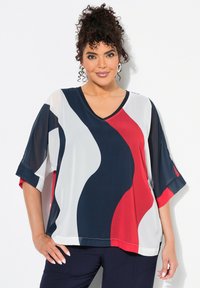 Top trasparente e leggero con scollatura a V e maniche corte. Il design presenta motivi ondulati nei colori blu navy, rosso e bianco.