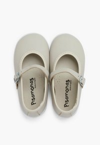 Zapatos Mary Jane de cuero beige con punta redonda, hebilla plateada y plantilla estampada. Textura suave con una suela blanca resistente.