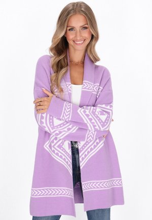 Lavendel cardigan met witte geometrische patronen, open voorkant, lange mouwen, zachte textuur en een ontspannen pasvorm, gecombineerd met een witte top en jeans.