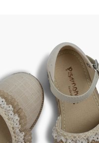 Beige platformové boty se krajkovým okrajem, textilním svrškem, nastavitelným páskem na kotníku a gumovou podrážkou. Texturovaná tkanina s detailním kostkovaným vzorem.