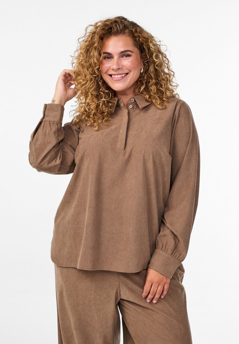 Long-sleeve brown corduroy shirt with a button-up collar and cuffed sleeves, featuring a relaxed fit and a subtle striped texture.