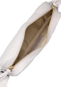 Borsa in pelle chiara con chiusura a zip; l'interno presenta una fodera in tessuto e una piccola tasca; dettagli in metallo dorato e nodo decorativo.