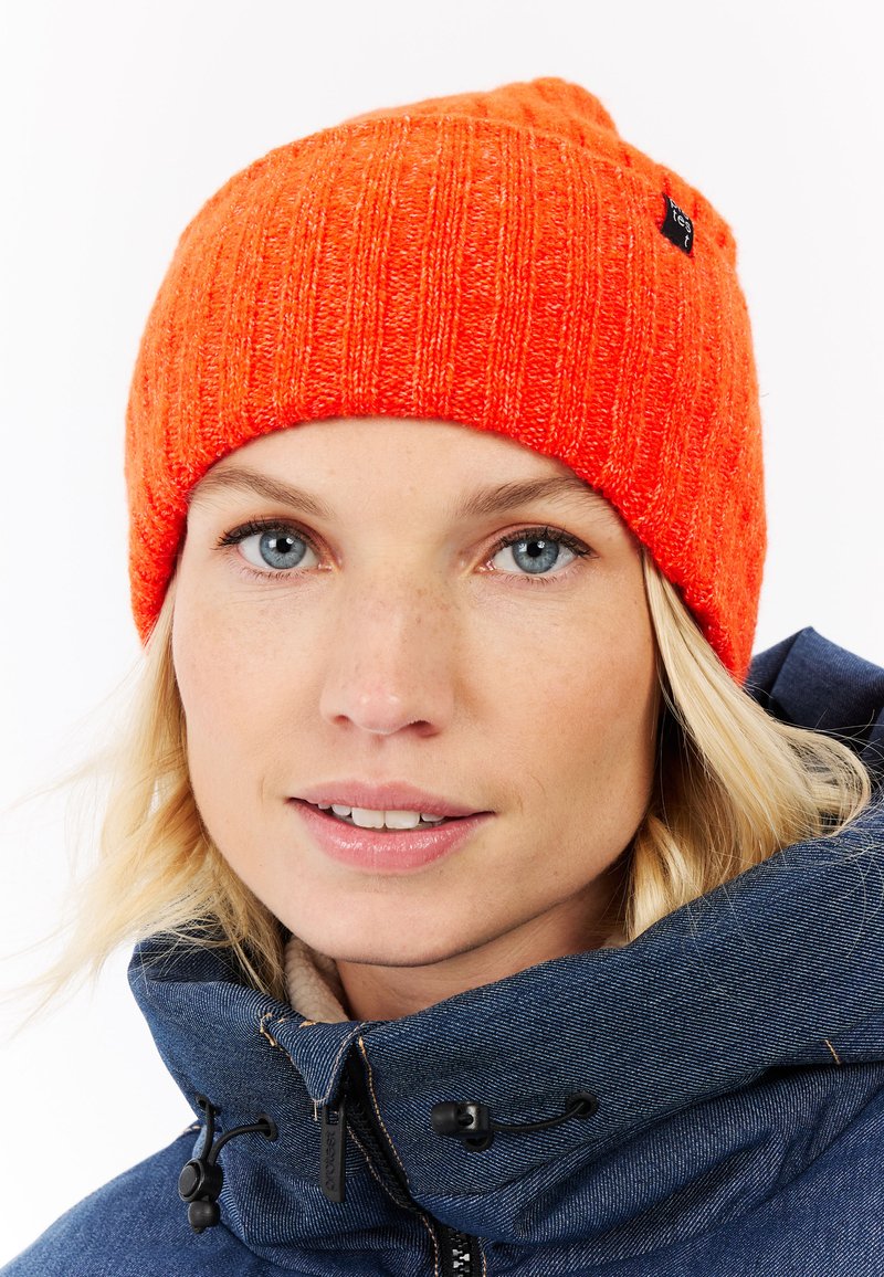 Heldere oranje gebreide beanie met een geribbeld patroon en een opgerolde rand. Heeft een klein zwart merketiket aan de zijkant.