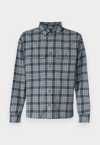 Camisa a cuadros azul y beige con cuello de botón, mangas largas, dos bolsillos en el pecho y botones de madera hechos de tela tejida.