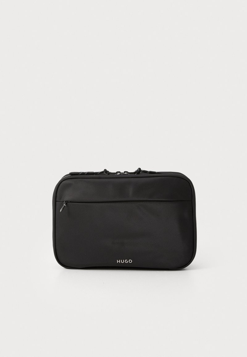 Svart nylonresväska med en stilren rektangulär form, utrustad med en framficka med dragkedja och subtil logodetalj längst ner.