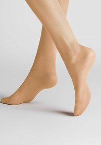 Nackte, transparente Strumpfhosen, glatte Textur, enganpassende Form, mit verstärkten Zehen- und Fersenkanten, auf einem hellgrauen Hintergrund liegend.