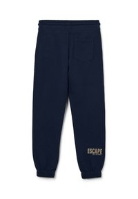 Pantalons de survêtement navy avec taille élastique, poignets côtelés et une poche arrière. Présente "ÉCHAPPER À L'ORDINAIRE" imprimé en beige sur la jambe.