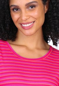 Gestreiftes Oberteil mit rundem Halsausschnitt, aus geripptem Stoff in Tönen von Rosa und Orange, das kontrastierende horizontale Streifen betont.