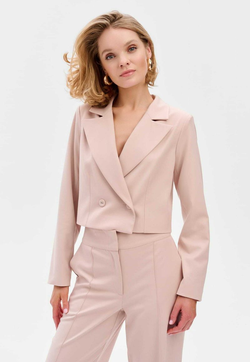 Geknipt blush-coloured blazer met een gelapte kraag, dubbele knoopsluiting en lange mouwen, gecombineerd met bijpassende fitted pantalon. Soepele textuur.