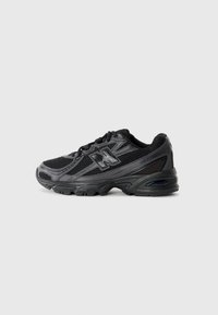 Schwarze Sportschuhe aus Mesh- und Synthetikmaterial. Sie verfügen über eine abgerundete Zehenpartie, einen gepolsterten Schaft, eine Schnürdesign und eine strukturierte Sohle.