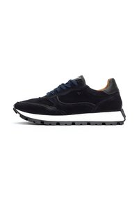 Navy suede kengät, joissa on valkoinen kumipohja, mustat yksityiskohdat ja siniset nauhat. Huomattava matala profiili ja tekstuuripintaiset yksityiskohdat.