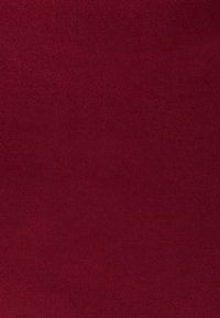 Vienojo tumši sarkana teksturēta auduma ar mīkstu, blīvu austu un nedaudz atšķirīgām toni variācijām visā tā virsmā.