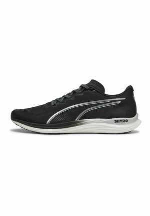 Schwarze Sport Schuhe mit einem schlanken, aerodynamischen Design. Hergestellt aus Netzmaterial, mit einem silbernen Akzentstreifen und einer weißen Sohle.
