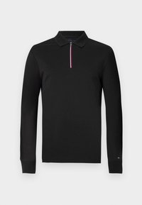 Polo de manga larga negro con cuello de cremallera. Presenta una franja contrastante en rojo, blanco y azul en la cremallera. Tejido suave y liso.