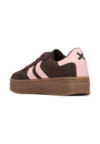 Sneaker in suede marrone con dettagli rosa, caratterizzati da tre strisce scure, una suola testurizzata e un logo nero sul tallone.