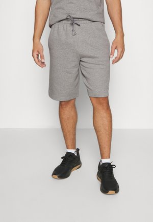 Sivé bavlnené šortky s elastickým pásom a šnúrkou. Nosí sa s čiernymi športovými topánkami. Tkanina je mäkká s hladkým povrchom.