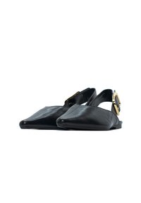 Ballerine slingback in pelle nera con punta affusolata, texture liscia e un accento in oro sulla cinghia alla caviglia.
