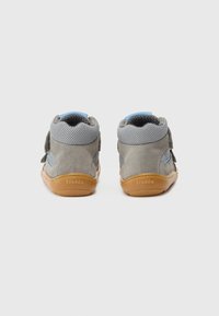 Grå ruskind og mesh ankelstøvler med velcrolukninger og blå accenter. Rundt tåg og gummisål i naturfarve. Bagfra set, med brandingdetalje.