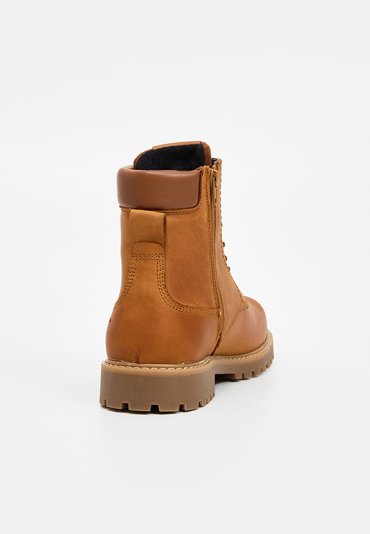 Bottines en cuir brun avec une finition texturée, dotées d'une fermeture éclair, d'un col rembourré et d'une semelle en caoutchouc robuste.