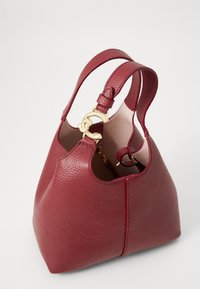 Burgundy leather handbag with textured surface; features two short handles and gold hardware accent on the closure.
