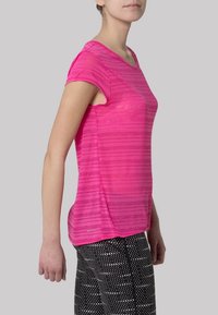 Růžové sportovní tričko s krátkým rukávem, pruhovaným vzorem, měkkou texturou a volným střihem, kombinováno s černými legínami s puntíky.