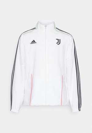 Giacca da pista bianca con strisce nere sulle maniche, logo Adidas nero e emblema della Juventus. Presenta un collo alto e chiusura con zip.