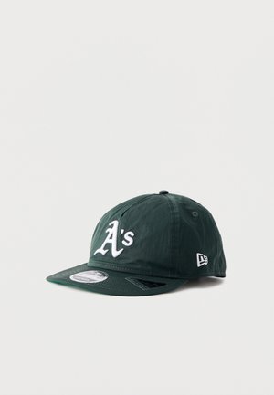 Tummanvihreä baseball-lippalakki, jossa valkoinen "A's"-logo edessä ja New Era -logo sivulla, litteä lippa, jossa bränditarra.