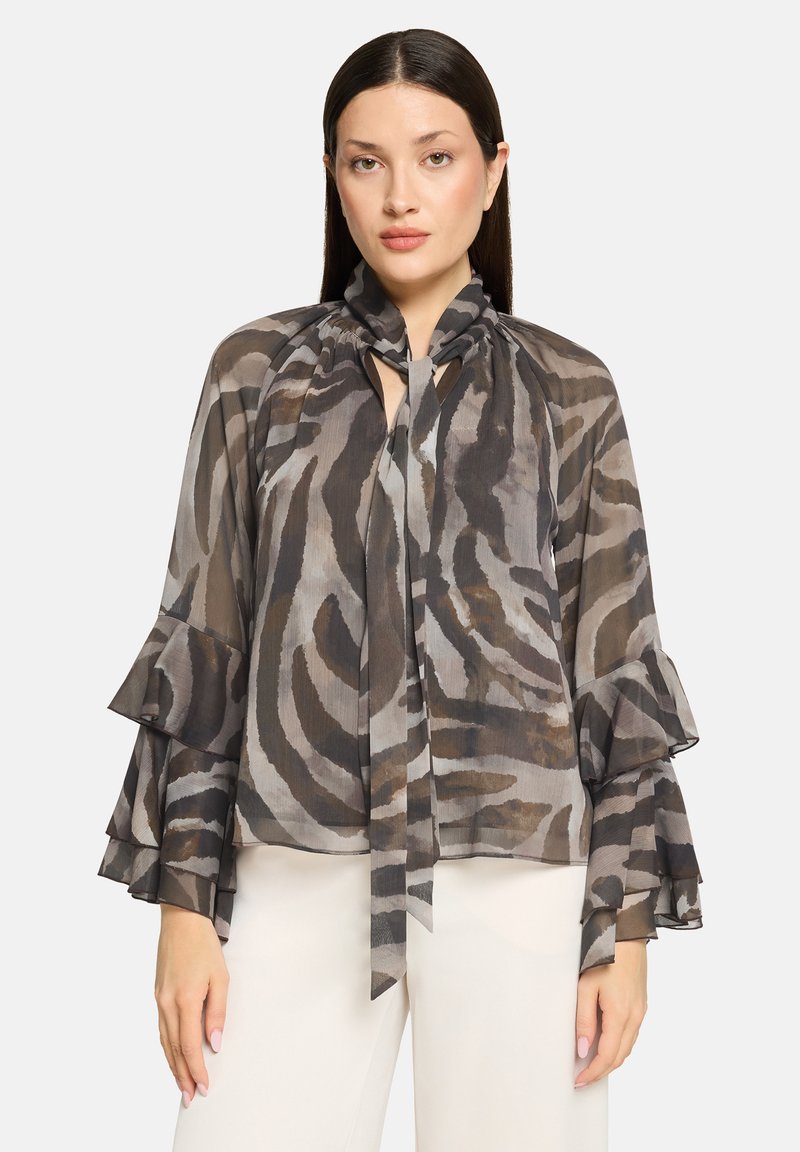 Blouse transparente à motifs dans des tons de gris et brun, dotée d'un col noué et de manches à volants pour une silhouette fluide.