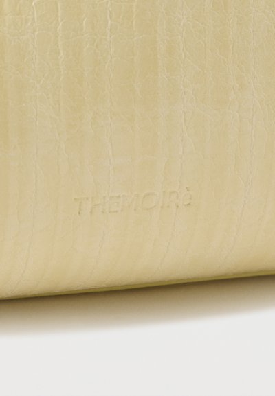 Υφή από λευκό δέρμα κρέμας με διακριτικό ανάγλυφο λογότυπο "THERMOIRé" στο κέντρο.