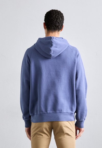 Fleeced azul com um capuz grande, punhos e bainha canelados. Tecido suave com uma textura lisa, mostrado de costas.