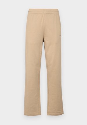 Beige bomullssweats i rett ben-design, med elastisk midjebånd og en liten logo-detalj på siden.