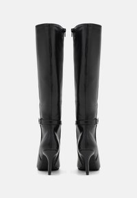 Stivali neri al ginocchio in pelle lucida, con tacco a stiletto e dettagli in fibbia sulla fascia, dalla texture elegante e liscia.